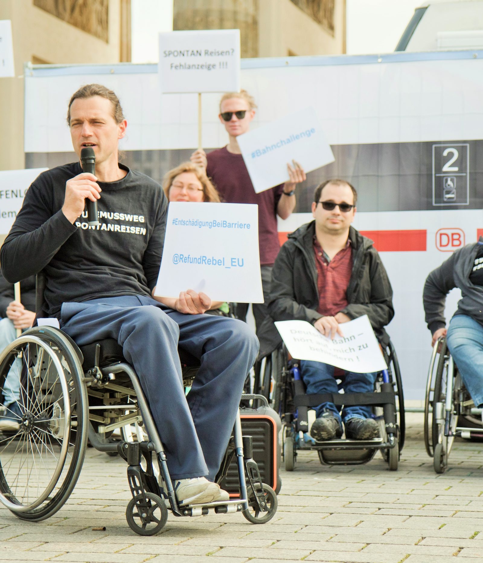 Mensch im Rollstuhl bei Protestaktion für eine barrierefreie Bahn zeigt Spendencheck Foto: Marcus Gebhardt