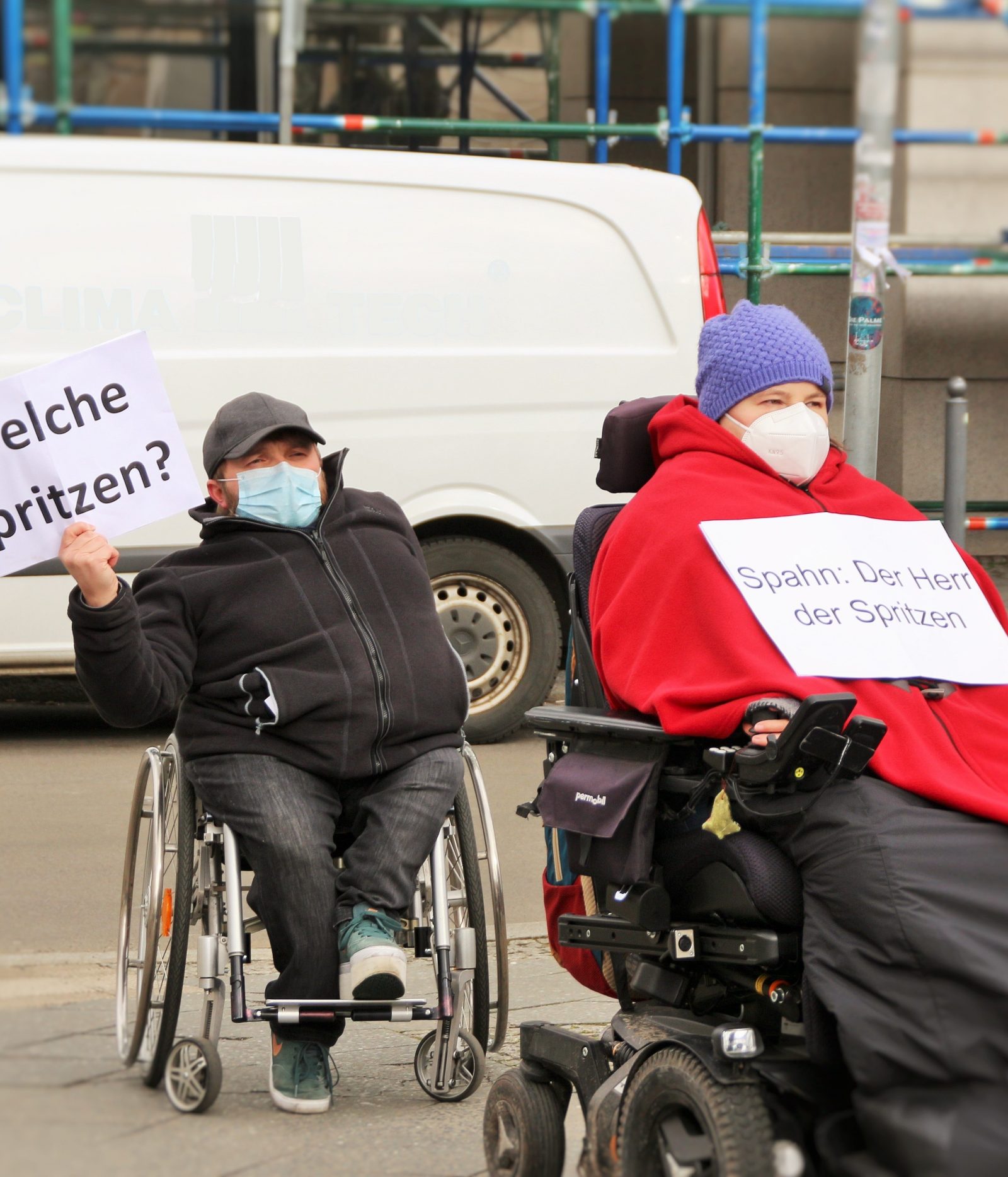 Menschen im Rollstuhl halten Schilder in die Luft bei einer Protestaktion. Foto: ISL e.V.