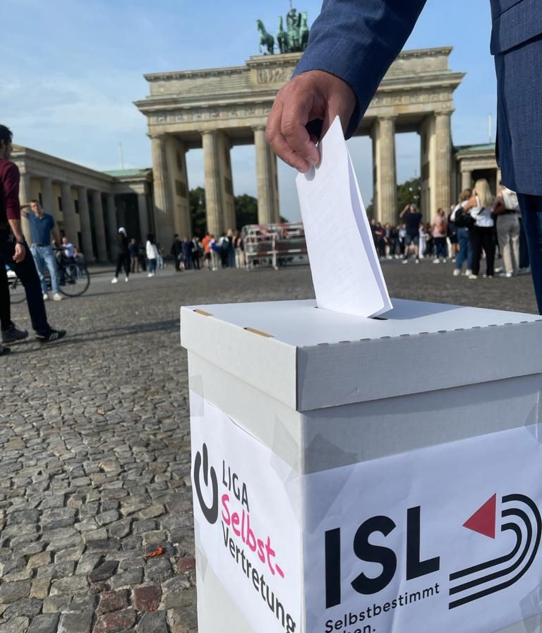 Wahlaktion am Brandenburger Tor. Zettel wird in Wahlurne gesteckt. Foto: Franziska Vu