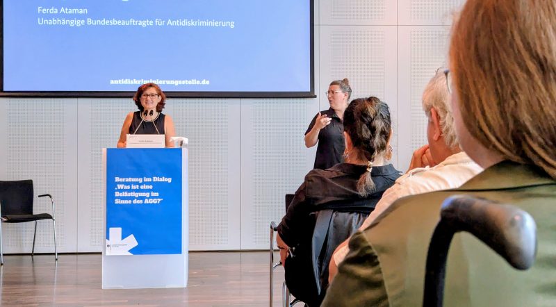 Ferda Ataman spricht am Redepult zu den Teilnehmenden bei einer Veranstaltung.